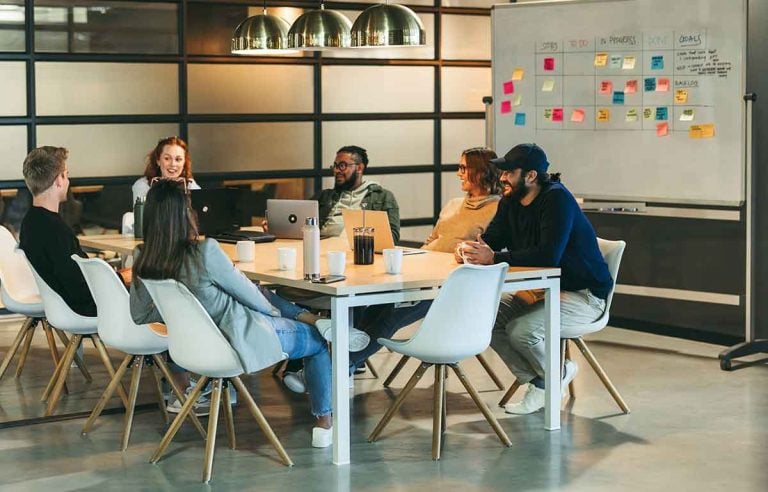 Scrum teams working together around a shared board contrasted with siloed teams separated by gaps, symbolizing the difference between cross-functional and component teams